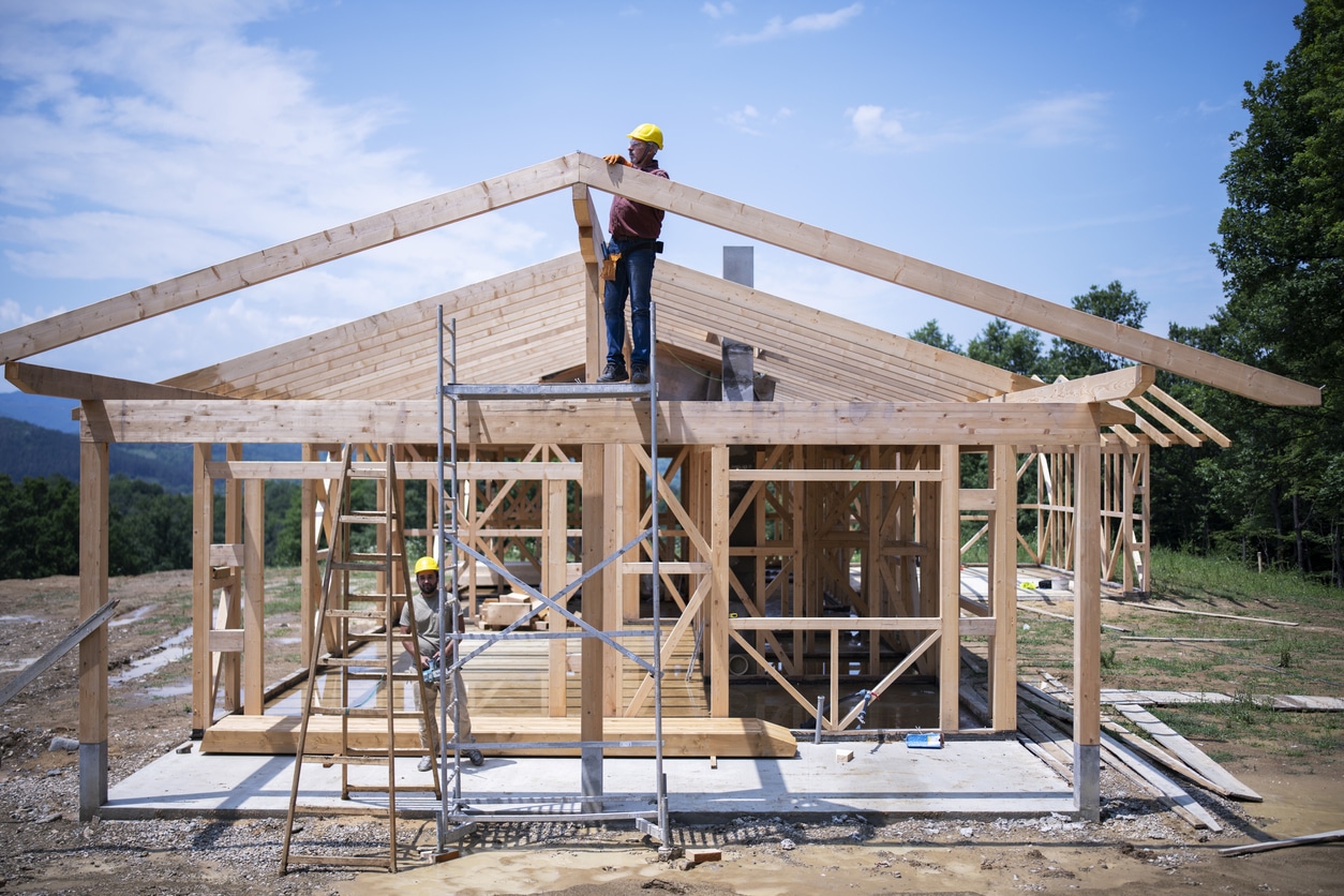 Two construction workers working on a house