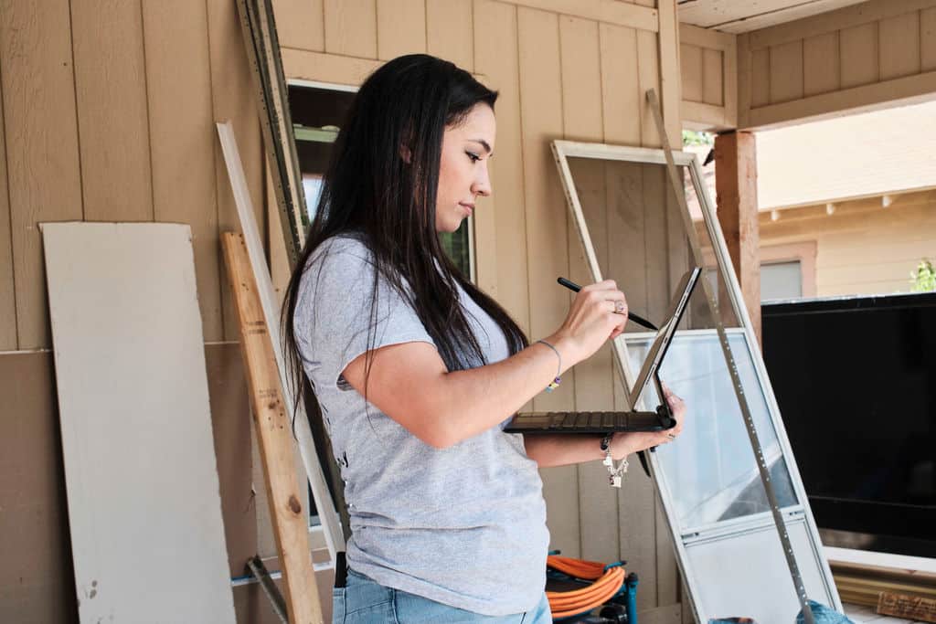 An estimator works on site using Buildxact on her laptop.