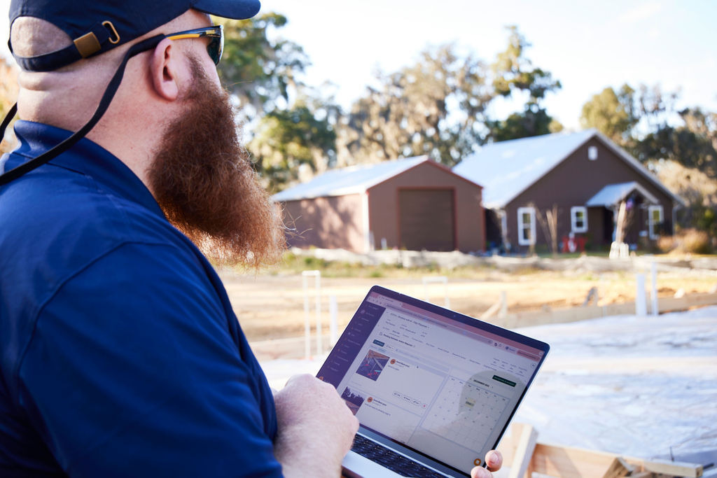 A customer on the job site uses a laptop to access Buildxact.