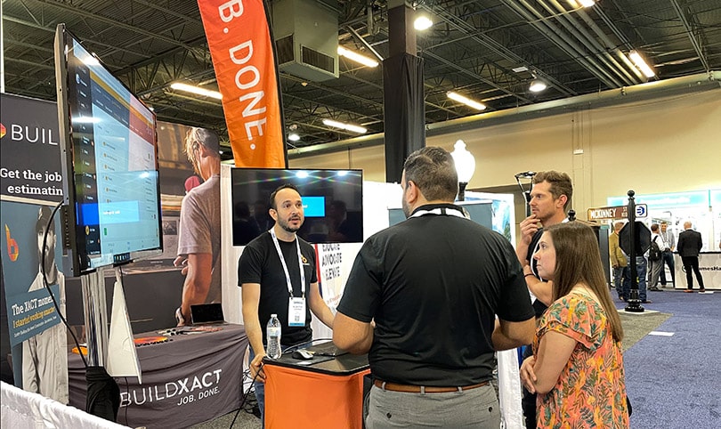 A Buildxact employee speaks to builders attending a trade show.