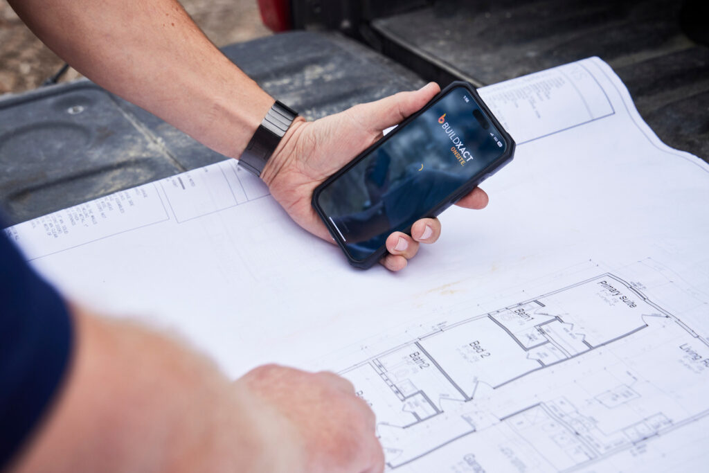 A builder uses the Buildxact Onsite mobile app from his job site