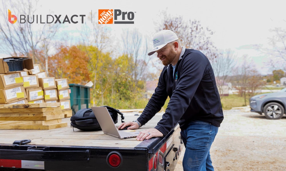 Buildxact customer Joshua Bradley works on a laptop sitting on his truck bed.